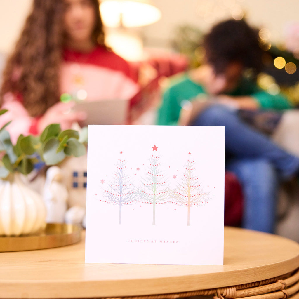 Stunning Silver Tree Trio Christmas Card is open and placed on top of a coffee table.
