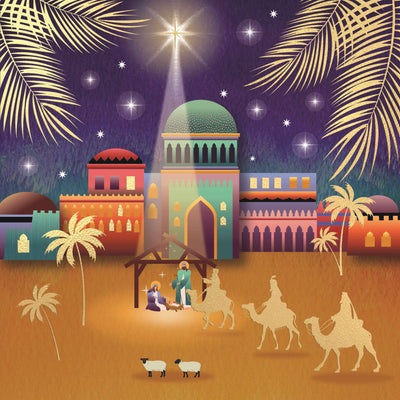 A charity Christmas card featuring a Christmas nativity scene illustration with a glowing star above a stable, colourful buildings, palm trees, camels, and sheep on a desert ground.