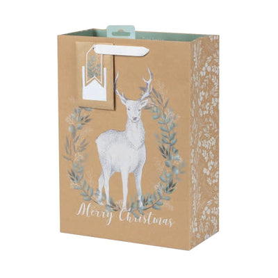 Festive brown gift bag featuring a white deer inside a green leaf wreath with 'Merry Christmas' text, white floral side patterns, and a matching gift tag.