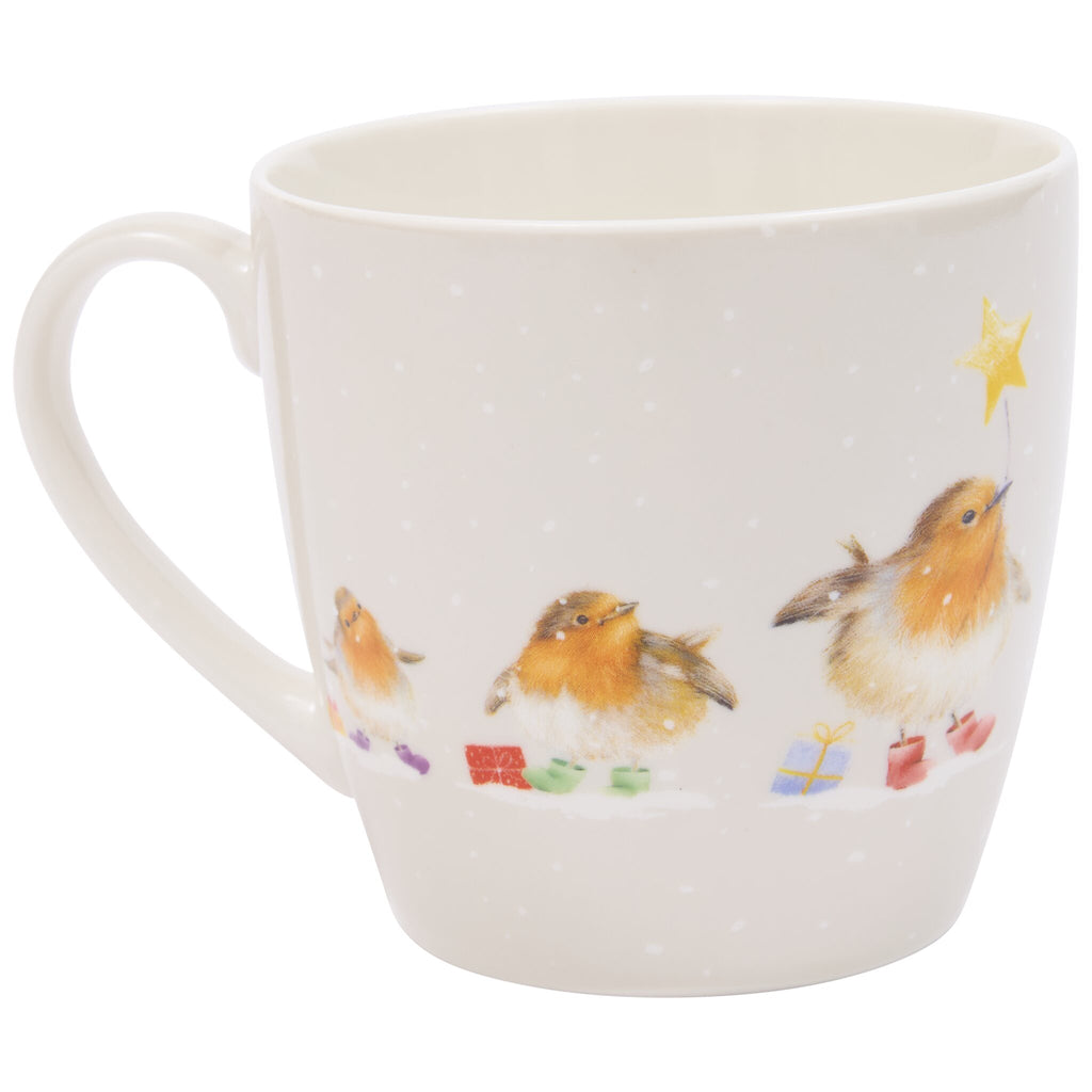 A white ceramic mug featuring three birds standing on snow, surrounded by small wrapped gifts, with one bird holding a yellow star on a string above its head