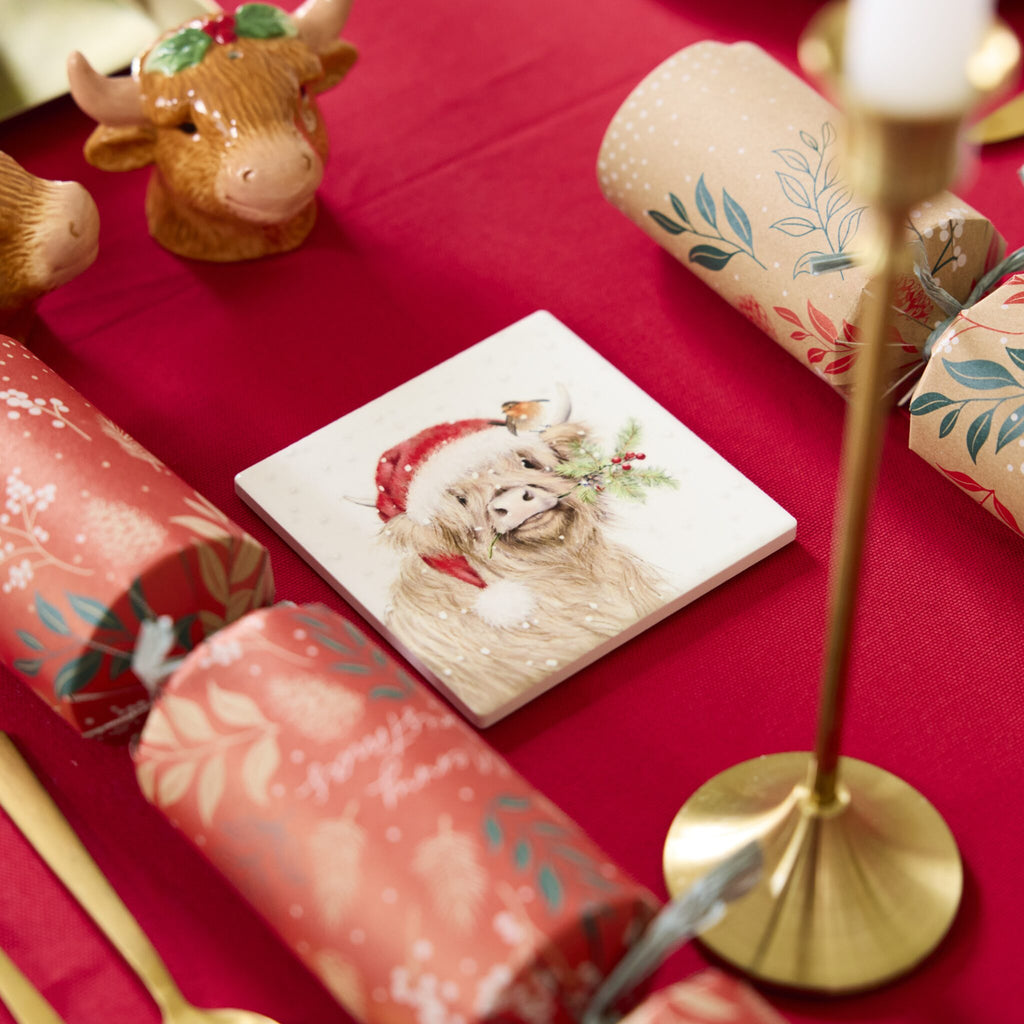 Highland Cow coaster sits on a festive table.