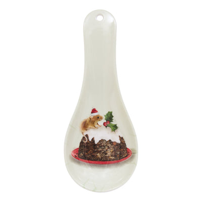 A white ceramic Christmas pudding spoon rest featuring a printed illustration of a pudding with a mouse wearing a Santa hat and green holly leaves on a red plate, set against a plain white background.