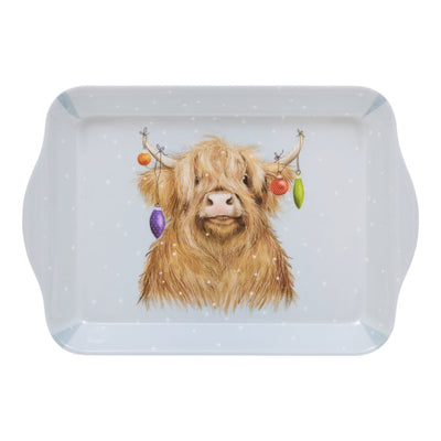 A rectangular light blue tray with rounded corners and handles, featuring a printed illustration of a fluffy Highland cow decorated with colourful hanging baubles against a white background.
