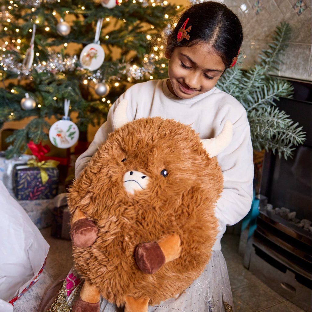 Girl holding the Extra large highland cow hand warmer. Great for chilly winter days.