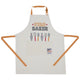An adult-sized apron with orange straps, designed for the Great Stand Up To Cancer Bake Off. The apron is white and features the words “Star Baker” above colourful illustrations of baking utensils, with a large front pocket.