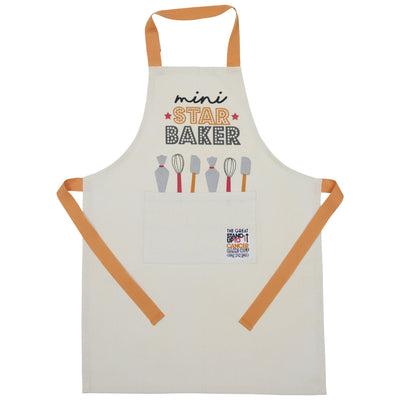 A cream-coloured children's apron with orange neck and waist straps. The chest features the phrase 'mini STAR BAKER' above illustrations of baking utensils. A large front pocket displays a small patch with 'The Great Stand Up To Cancer Bake Off' branding."