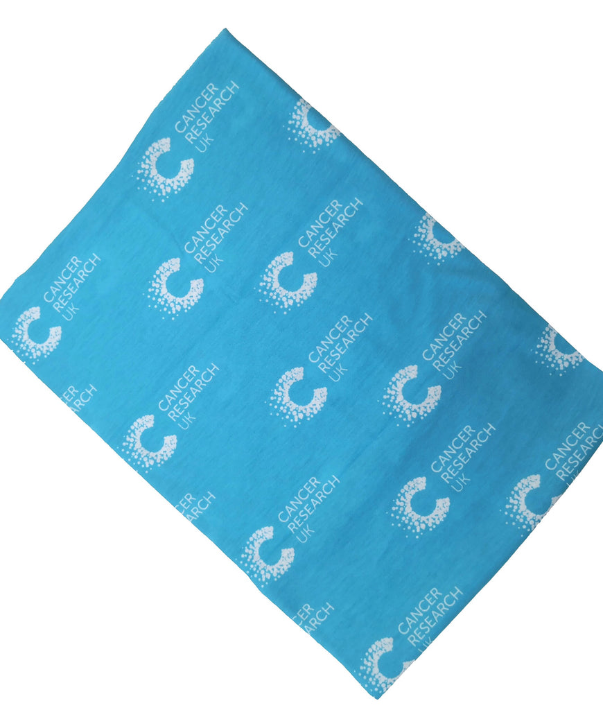 Blue multifunctional snood with Cancer Research pattern displayed flat. Ideal for post-chemo recovery, with soft, breathable fabric that won’t irritate sensitive skin.