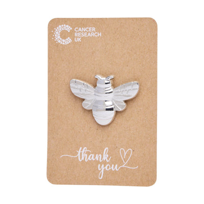 Silver bee wedding favour on a backing card featuring the Cancer Research UK logo and a thank-you message.