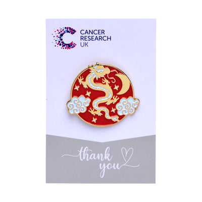 Golden dragon wedding favour on a backing card featuring the Cancer Research UK logo and a thank-you message.