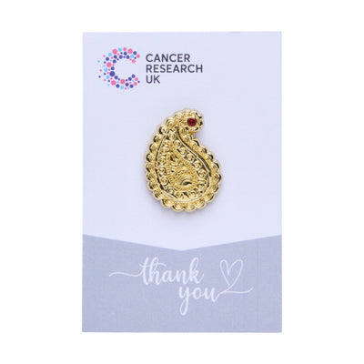 Gold paisley wedding favour on a backing card featuring the Cancer Research UK logo and a thank-you message.
