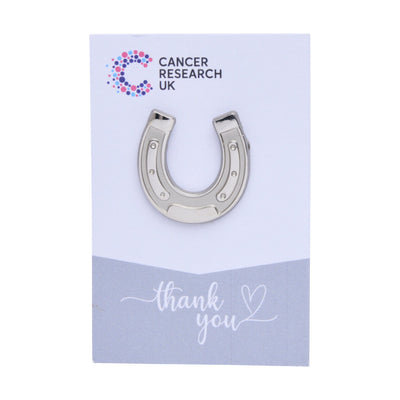 Silver horseshoe wedding favour on a backing card featuring the Cancer Research UK logo and a thank-you message.