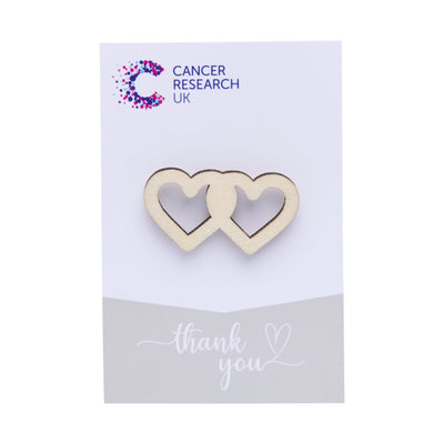 Wooden hearts wedding favour on a backing card featuring the Cancer Research UK logo and a thank-you message.